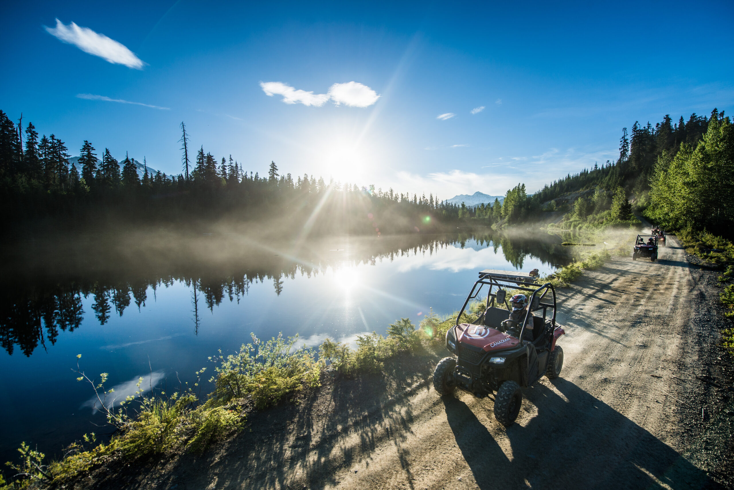 An off-road buggy kicking up dust on a forest trail near Whistler