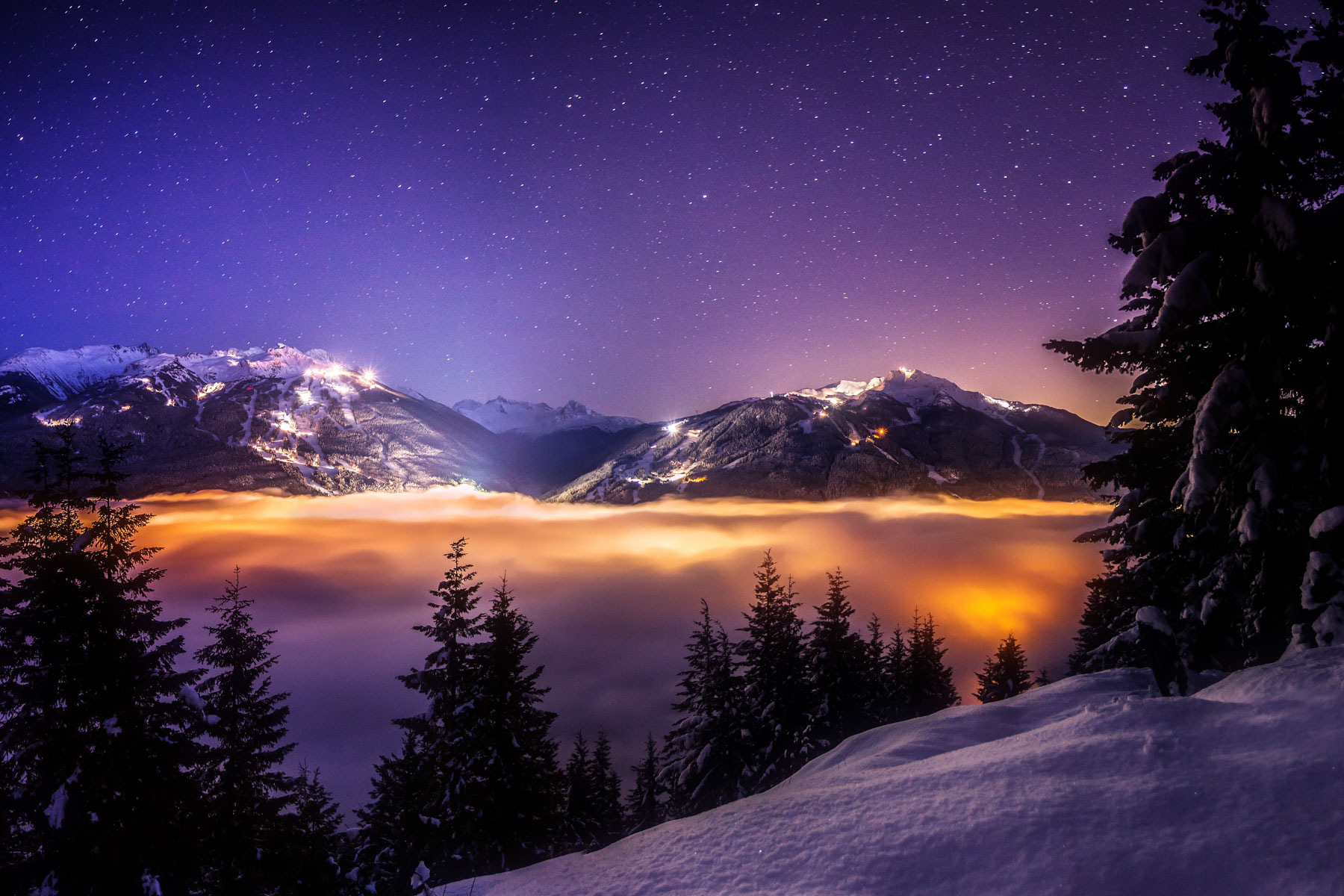 Whistler and Blackcomb peaks above a sea of cloud at dusk
