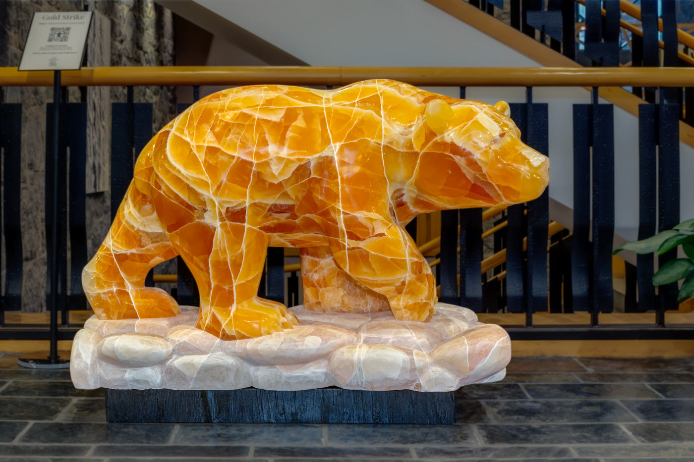 A large orange calcite bear sculpture on display at Fathom Stone Art inside the Westin Resort and Spa, Whistler