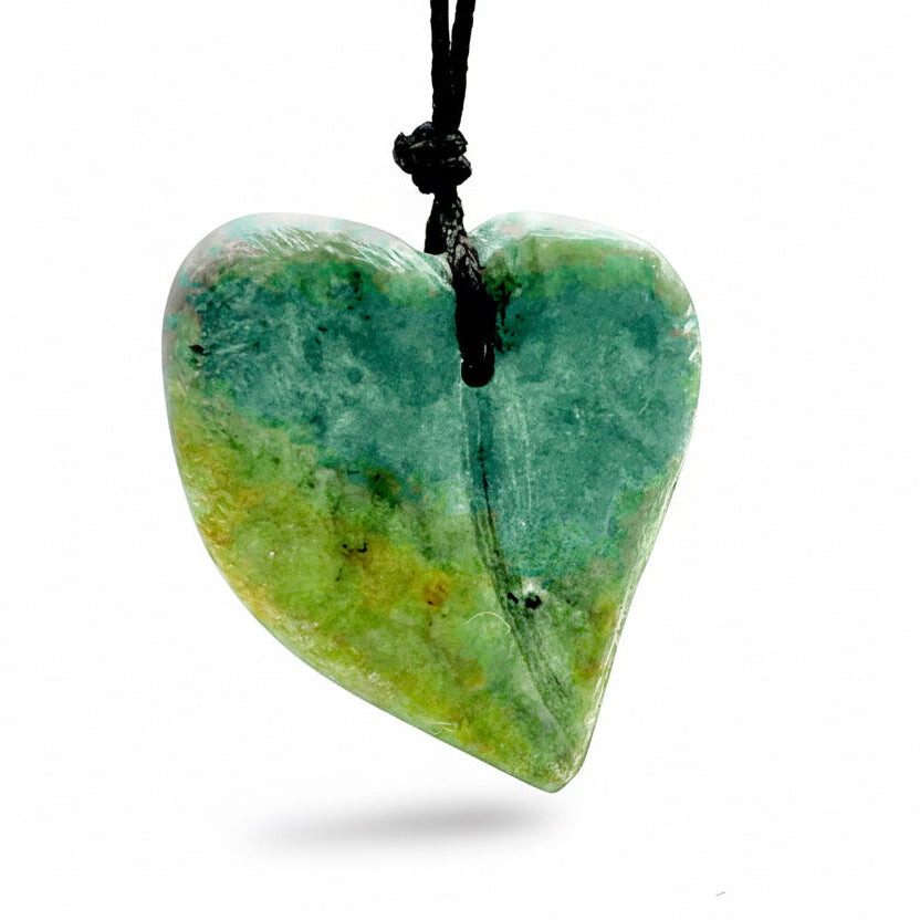 A green heart-shaped soapstone pendant on a black cord, carved in a class at Fathom Stone Art