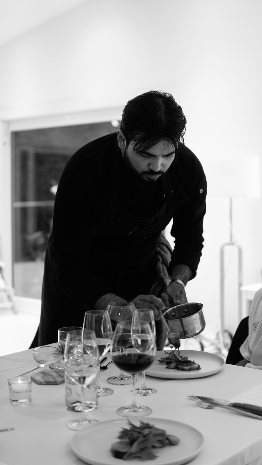Chef Krishna Patel of Vénerie Private Dining plating a course at a private dinner