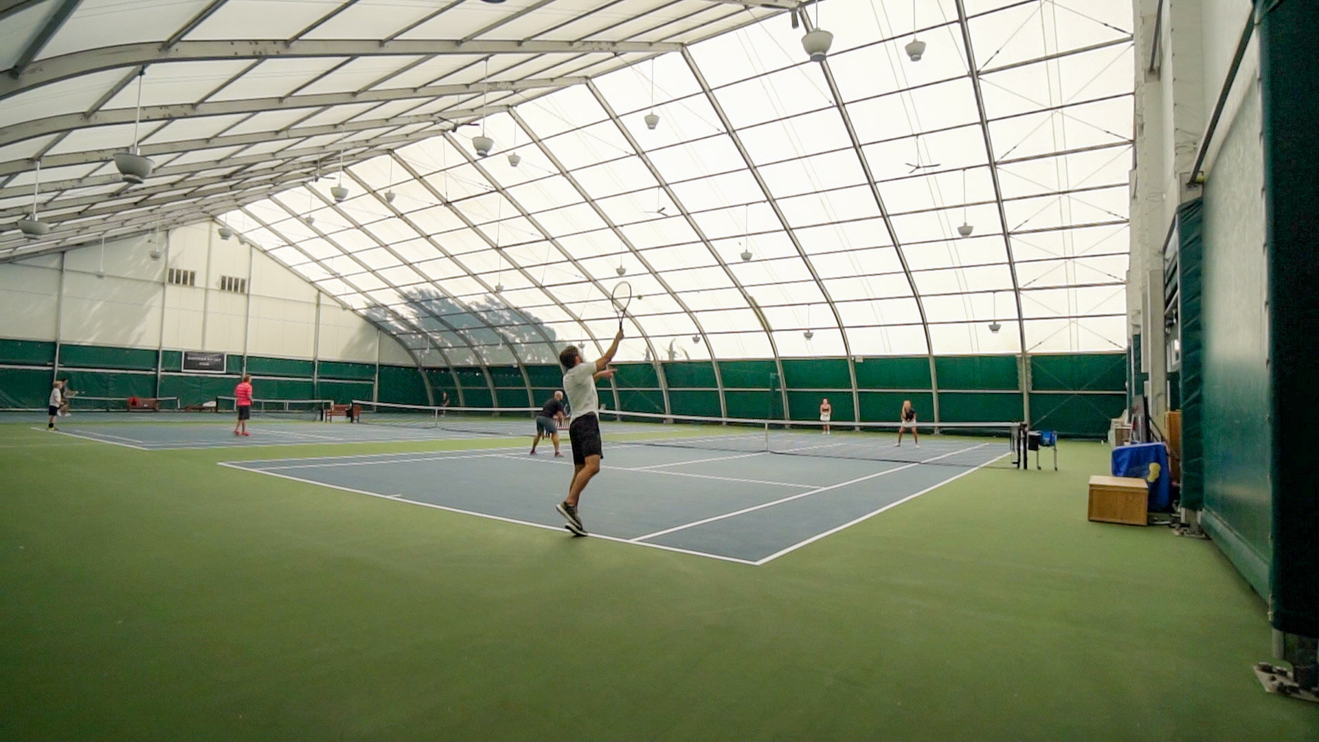 Tennis courts at the Whistler Racket Club with forested mountains behind