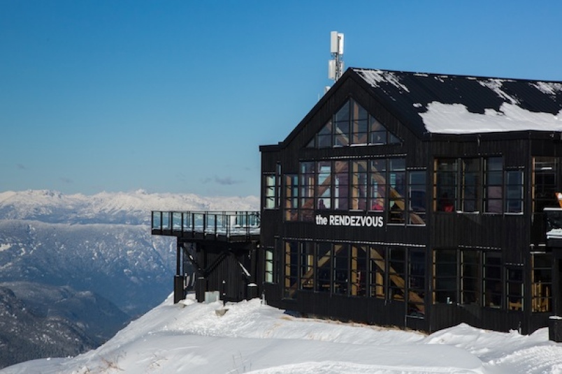 The black timber Rendezvous Lodge on a ridge at the top of Blackcomb