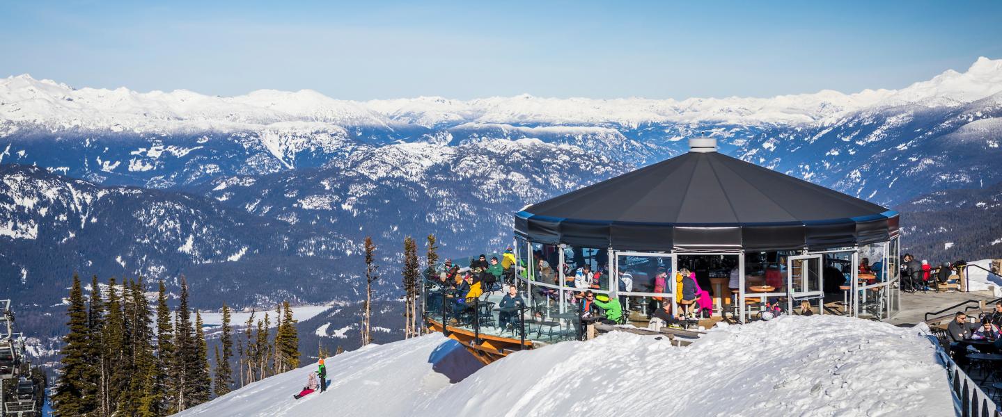 A mountaintop lodge patio on Whistler Blackcomb above a sea of Coast Mountain peaks
