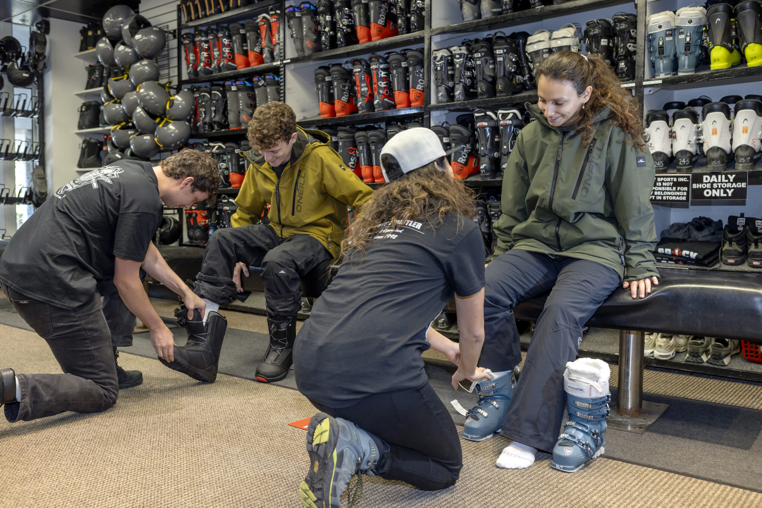 Spicy Sports staff fitting ski boots for guests in the rental shop
