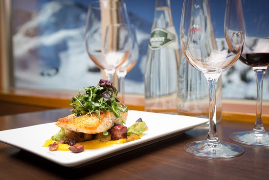 A plated fish dish with wine glasses at Steeps Grill and Wine Bar