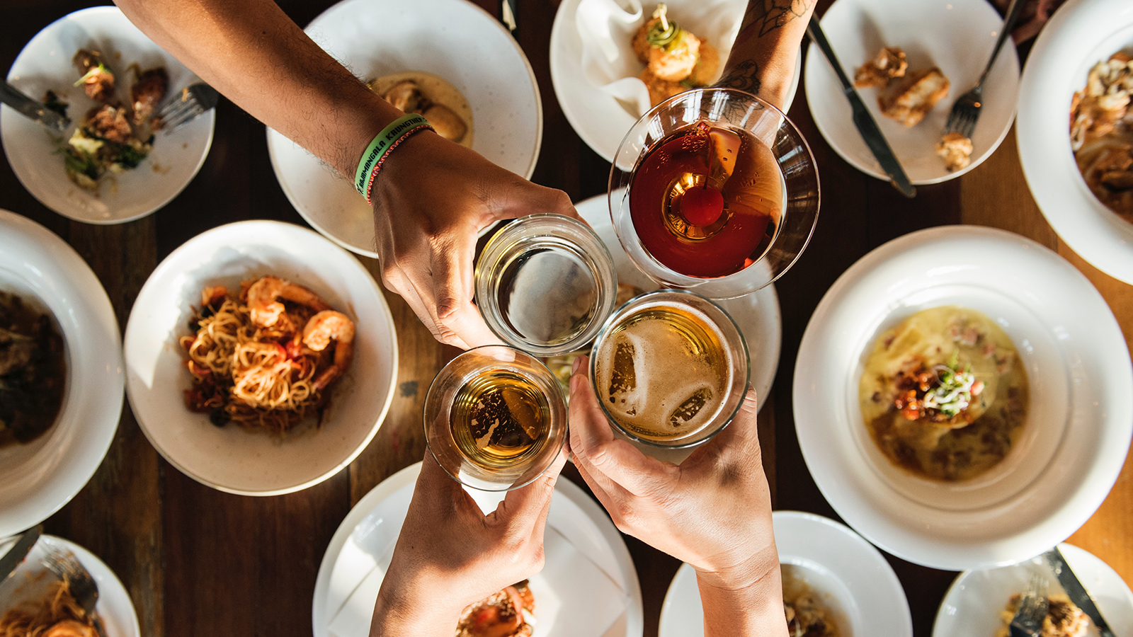 A group of guests raising glasses at a restaurant table on a Whistler tasting tour