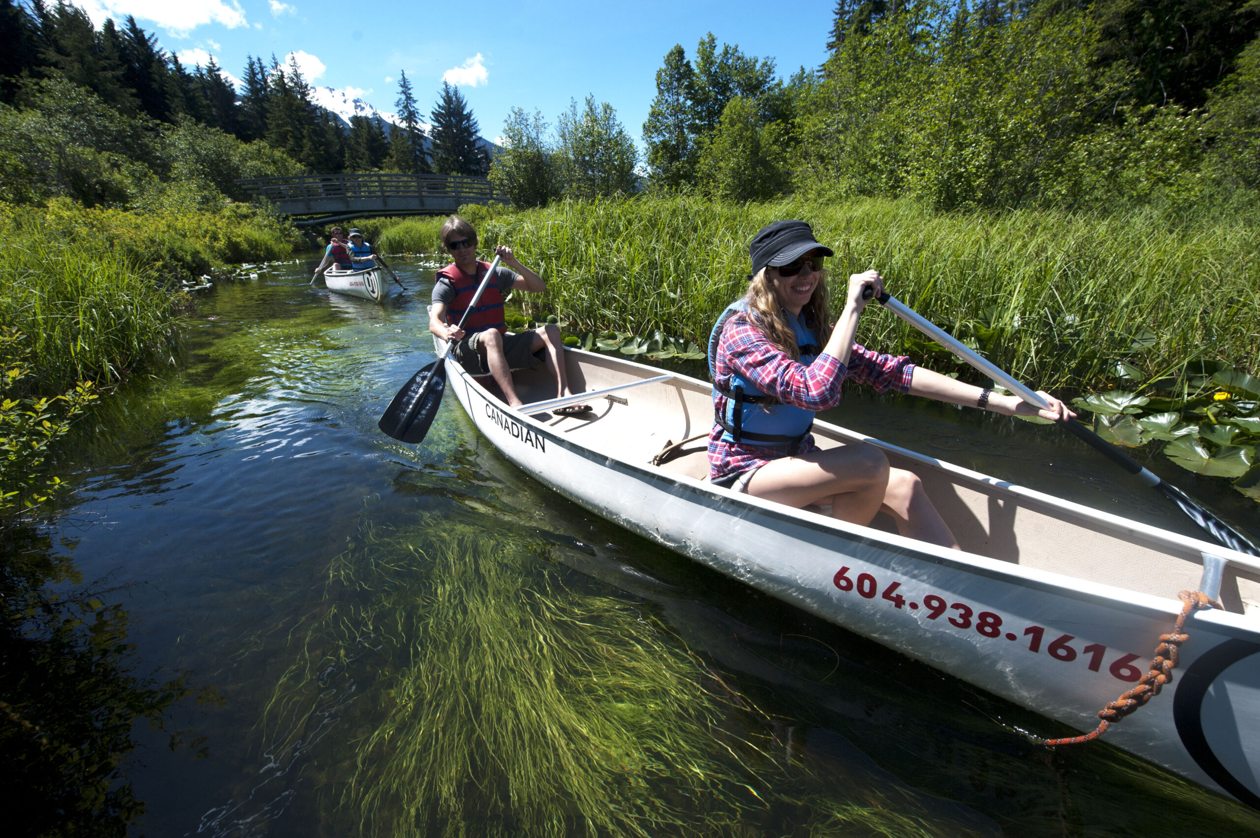 Canoes on the calm water of the River of Golden Dreams with forest on both banks